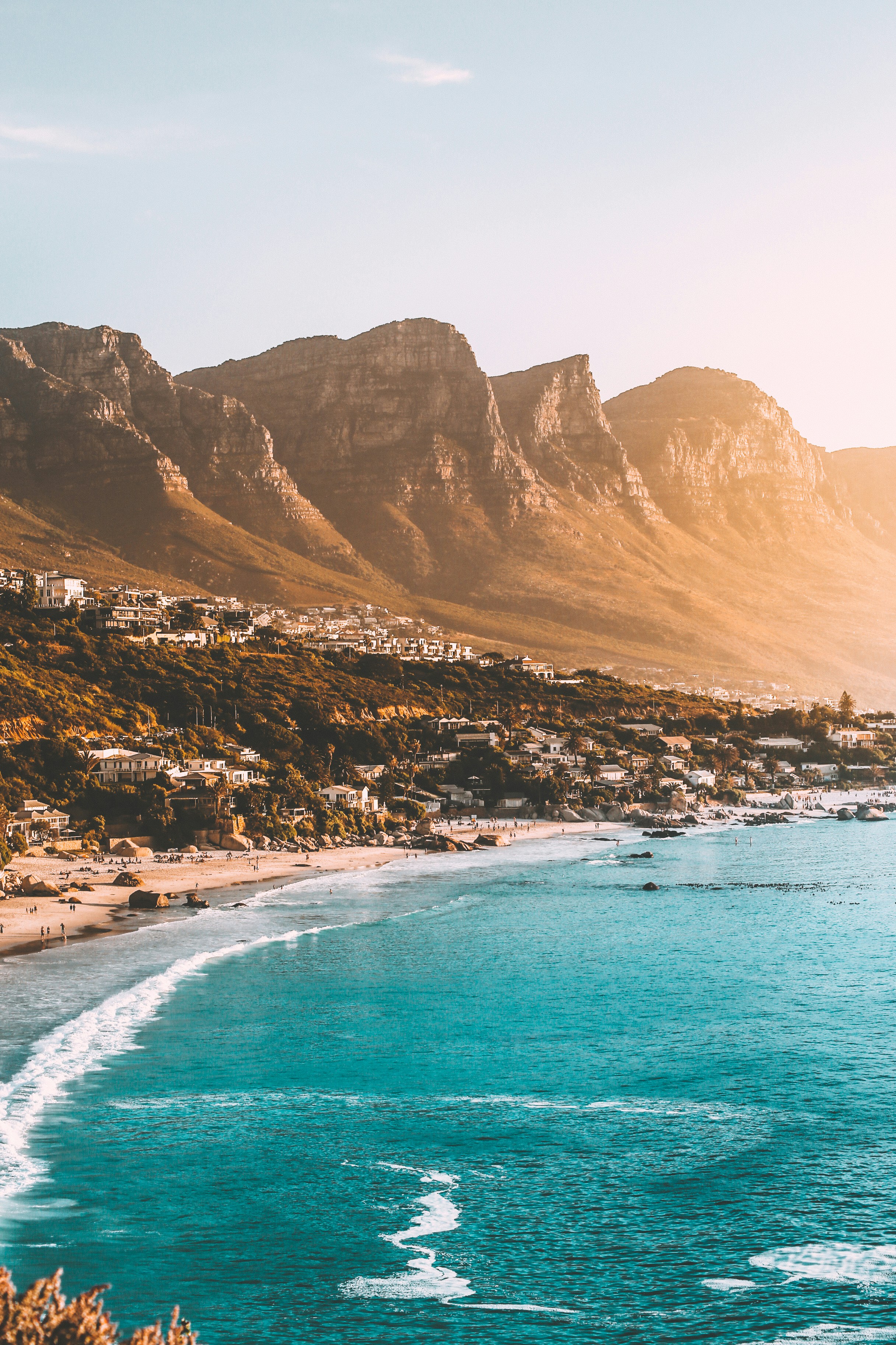 Cape Town coastline with turquoise water, sandy beaches and mountains in golden light